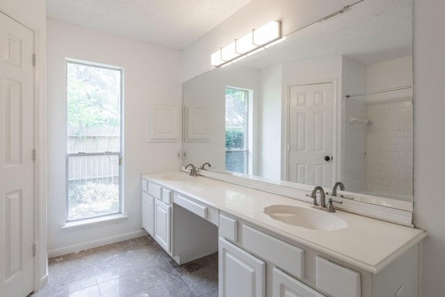 10107 Sands Trail Ct, Houston, TX 77064 - bathroom featuring double vanity, a textured ceiling, baseboards, a shower, and tile patterned floors