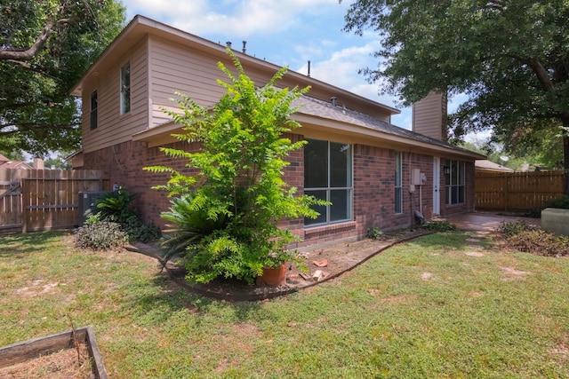 10107 Sands Trail Ct, Houston, TX 77064 - rear view of house with a chimney, brick siding, and central air condition unit