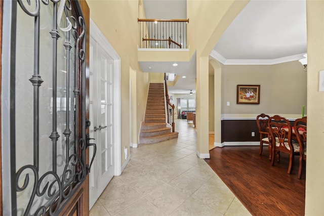26020 Bassfield Ln, Katy, TX 77494 - tiled foyer featuring arched walkways, baseboards, crown molding, and stairs