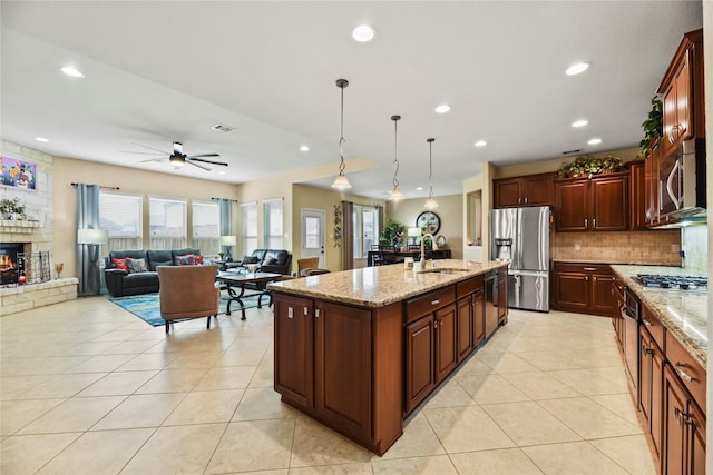 26020 Bassfield Ln, Katy, TX 77494 - kitchen featuring stainless steel appliances, a sink, light tile patterned floors, a ceiling fan, and tasteful backsplash