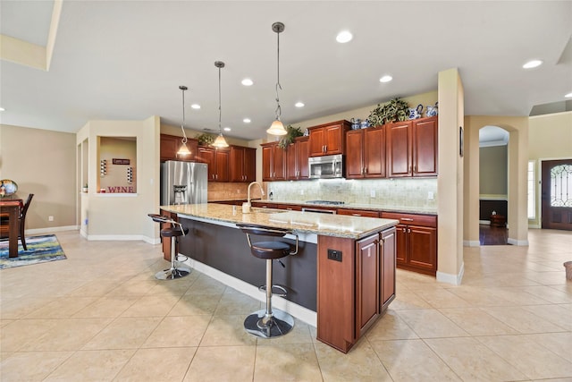 26020 Bassfield Ln, Katy, TX 77494 - kitchen featuring appliances with stainless steel finishes, a sink, light tile patterned floors, arched walkways, and recessed lighting