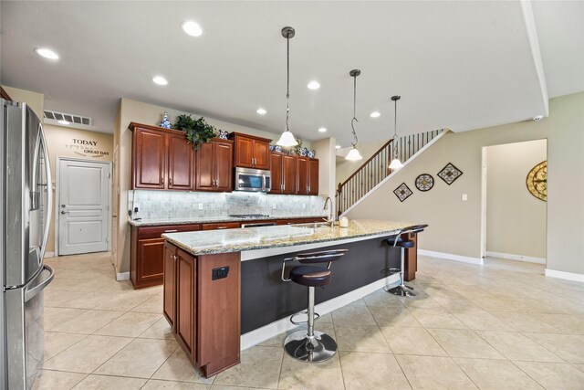 26020 Bassfield Ln, Katy, TX 77494 - kitchen featuring stainless steel appliances, a sink, backsplash, light tile patterned floors, and an island with sink