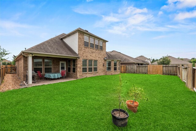 26020 Bassfield Ln, Katy, TX 77494 - rear view of house featuring a shingled roof, brick siding, and a patio
