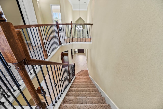 26020 Bassfield Ln, Katy, TX 77494 - staircase with a towering ceiling, a textured wall, and baseboards