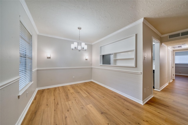 3224 Timmons Ln Unit 157, Houston, TX 77027 - empty room featuring a textured ceiling, a chandelier, wood finished floors, built in shelves, and baseboards