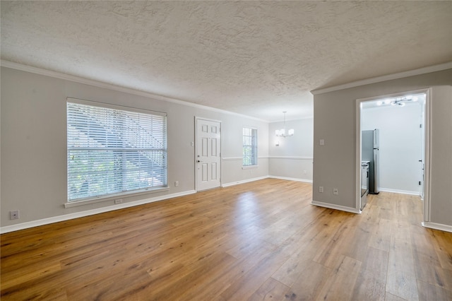 3224 Timmons Ln Unit 157, Houston, TX 77027 - unfurnished living room featuring a chandelier, light wood finished floors, crown molding, a textured ceiling, and baseboards