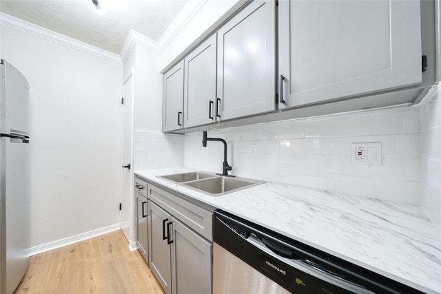 3224 Timmons Ln Unit 157, Houston, TX 77027 - kitchen with stainless steel appliances, a sink, ornamental molding, backsplash, and light wood-style flooring
