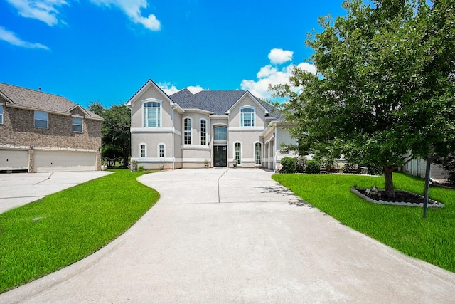 57 Cloverdale Ct, Montgomery, TX 77356 - french country style house with concrete driveway, a front yard, stucco siding, and a garage