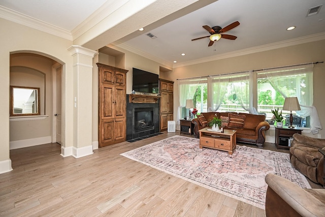 57 Cloverdale Ct, Montgomery, TX 77356 - living area with a ceiling fan, a fireplace with flush hearth, light wood finished floors, crown molding, and decorative columns