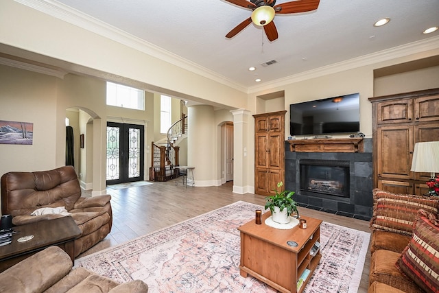 57 Cloverdale Ct, Montgomery, TX 77356 - living room with a ceiling fan, a tile fireplace, arched walkways, ornamental molding, and french doors