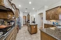 57 Cloverdale Ct, Montgomery, TX 77356 - kitchen featuring arched walkways, a kitchen island, recessed lighting, gas stovetop, and ornamental molding