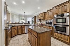 57 Cloverdale Ct, Montgomery, TX 77356 - kitchen featuring appliances with stainless steel finishes, ornamental molding, a kitchen island, dark countertops, and light tile patterned flooring