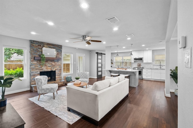 1139 Lehman St, Houston, TX 77018 - living room with baseboards, plenty of natural light, a barn door, dark wood finished floors, and recessed lighting