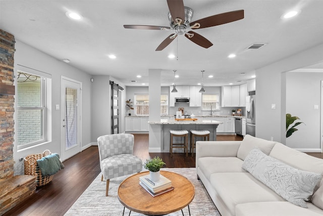 1139 Lehman St, Houston, TX 77018 - living room featuring dark wood-style floors, a ceiling fan, recessed lighting, baseboards, and a barn door
