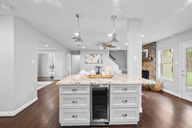 1139 Lehman St, Houston, TX 77018 - kitchen featuring wine cooler, white cabinets, a stone fireplace, baseboards, and recessed lighting