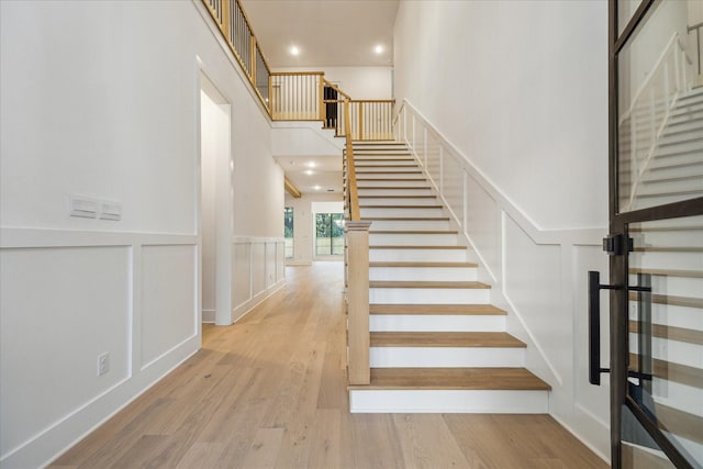 1112 Kinley Ln, Houston, TX 77018 - staircase with a decorative wall, wood finished floors, recessed lighting, wainscoting, and a towering ceiling