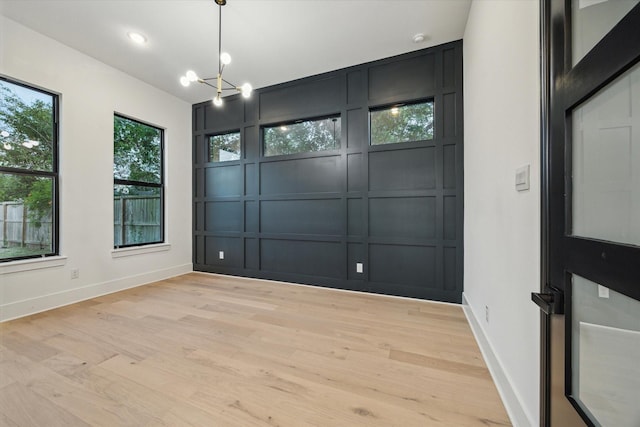 1112 Kinley Ln, Houston, TX 77018 - spare room with a decorative wall, light wood-style flooring, a chandelier, and a smoke detector
