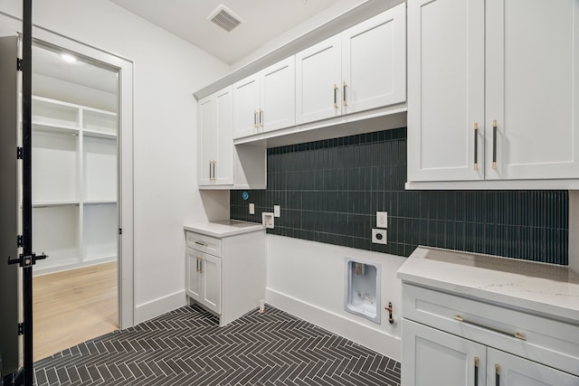1112 Kinley Ln, Houston, TX 77018 - kitchen with white cabinets, decorative backsplash, and light stone countertops