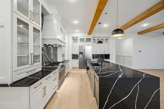 1112 Kinley Ln, Houston, TX 77018 - kitchen featuring appliances with stainless steel finishes, a spacious island, light wood-style floors, beamed ceiling, and decorative backsplash