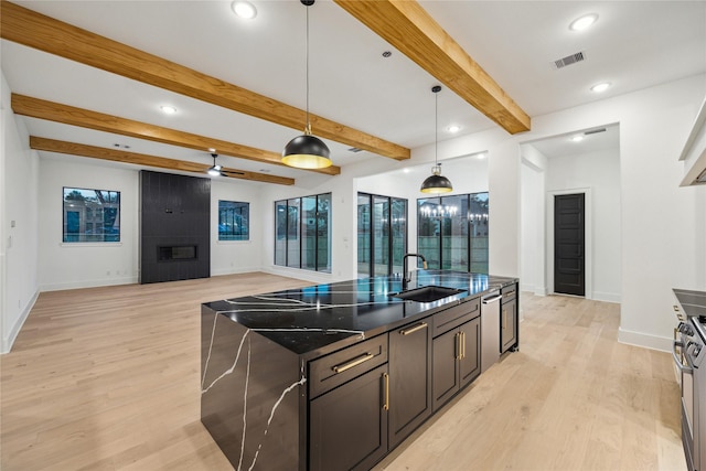 1112 Kinley Ln, Houston, TX 77018 - kitchen with recessed lighting, an island with sink, open floor plan, light wood finished floors, and a large fireplace