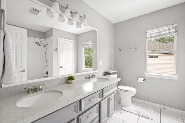 1706 Brightlake Way, Missouri City, TX 77459 - bathroom featuring a tile shower, double vanity, toilet, tile patterned floors, and baseboards