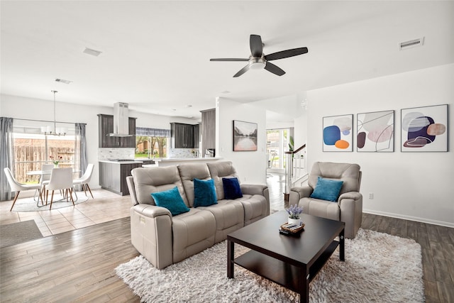 1706 Brightlake Way, Missouri City, TX 77459 - living room with a ceiling fan, a chandelier, wood finished floors, and baseboards