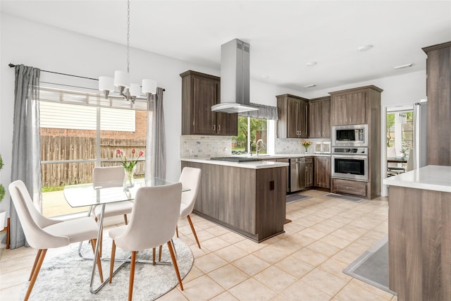 1706 Brightlake Way, Missouri City, TX 77459 - kitchen featuring stainless steel appliances, island range hood, light countertops, backsplash, and healthy amount of natural light