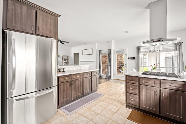 1706 Brightlake Way, Missouri City, TX 77459 - kitchen with stainless steel appliances, island range hood, light tile patterned floors, dark brown cabinets, and light countertops