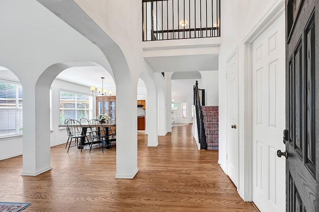 15427 Stonehill Dr, Houston, TX 77062 - entrance foyer with wood finished floors, a chandelier, a towering ceiling, baseboards, and arched walkways