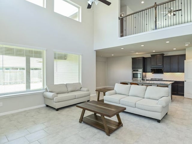 5422 Wildbrush Dr, Richmond, TX 77407 - living room with a ceiling fan, a towering ceiling, plenty of natural light, baseboards, and recessed lighting