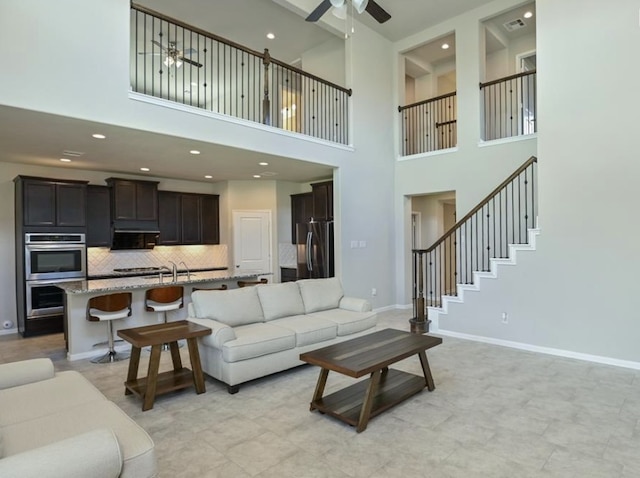 5422 Wildbrush Dr, Richmond, TX 77407 - living room with ceiling fan, a high ceiling, baseboards, and recessed lighting