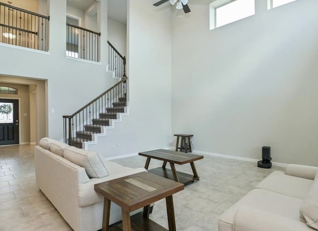 5422 Wildbrush Dr, Richmond, TX 77407 - living area featuring a high ceiling, stairway, a ceiling fan, and baseboards