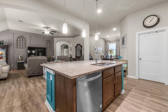 371 Westlake Terrace Dr, Conroe, TX 77304 - kitchen featuring dishwasher, a sink, arched walkways, light wood-style floors, and open floor plan