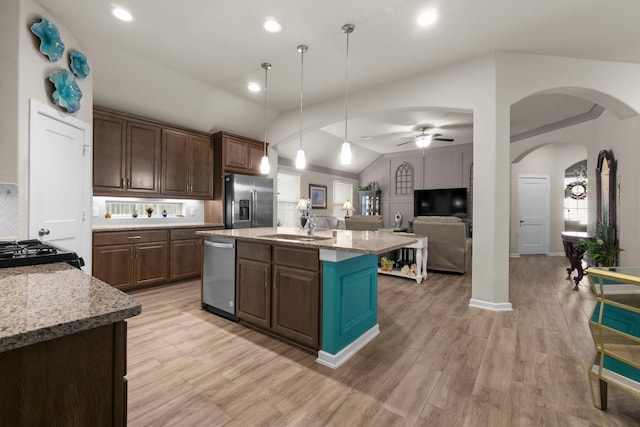 371 Westlake Terrace Dr, Conroe, TX 77304 - kitchen featuring appliances with stainless steel finishes, lofted ceiling, arched walkways, light wood-style floors, and open floor plan