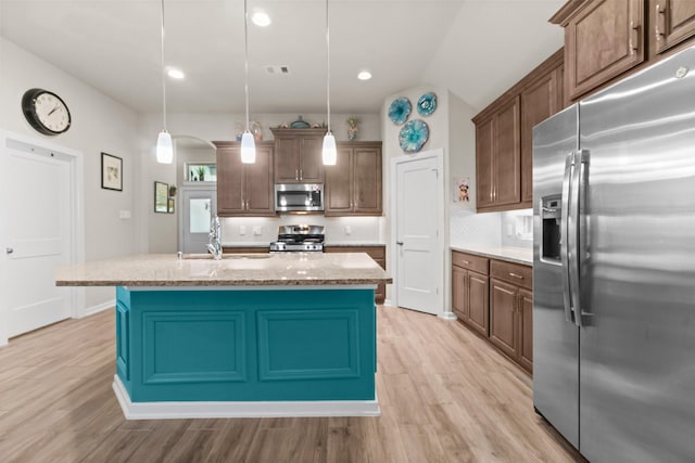 371 Westlake Terrace Dr, Conroe, TX 77304 - kitchen featuring stainless steel appliances, a sink, light wood-type flooring, decorative backsplash, and vaulted ceiling