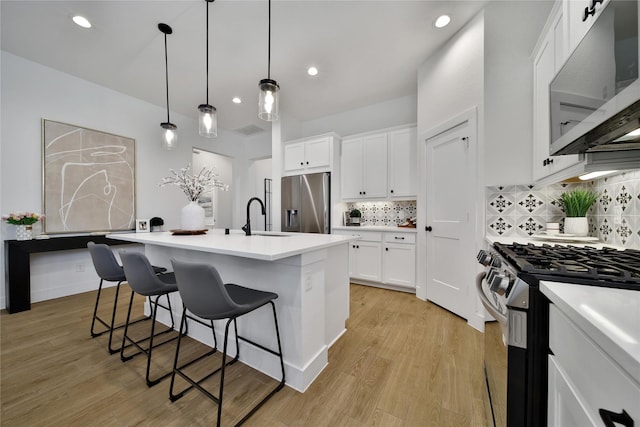 296 N Cascade Heights Dr, Montgomery, TX 77316 - kitchen with appliances with stainless steel finishes, a sink, a kitchen bar, backsplash, and white cabinets