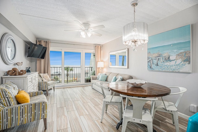 7310 Seawall Blvd Unit 210, Galveston, TX 77551 - dining room with a textured ceiling, ceiling fan, a chandelier, baseboards, and wood tiled floors