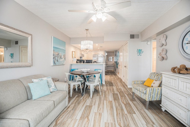 7310 Seawall Blvd Unit 210, Galveston, TX 77551 - living room featuring a chandelier, a ceiling fan, and light wood-style floors