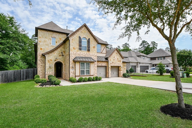 1704 Graystone Hills Dr, Conroe, TX 77304 - view of front of property featuring concrete driveway, a standing seam roof, an attached garage, stone siding, and roof with shingles