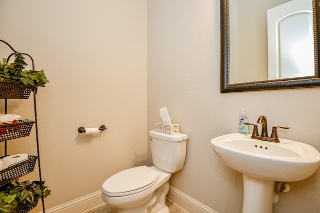 1704 Graystone Hills Dr, Conroe, TX 77304 - half bathroom featuring baseboards, toilet, and a sink