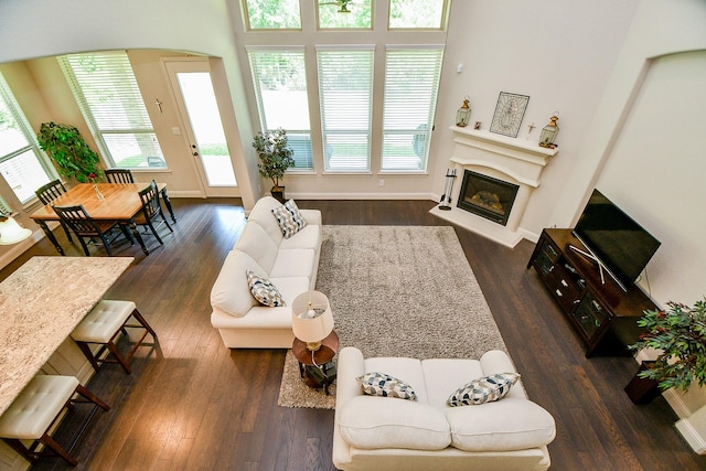 1704 Graystone Hills Dr, Conroe, TX 77304 - living area featuring plenty of natural light, a glass covered fireplace, and dark wood-style flooring