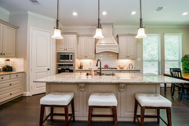 1704 Graystone Hills Dr, Conroe, TX 77304 - kitchen featuring stainless steel appliances, light stone countertops, a breakfast bar, decorative backsplash, and ornamental molding