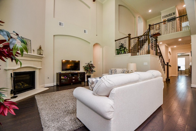 1704 Graystone Hills Dr, Conroe, TX 77304 - living area with a high ceiling, stairs, hardwood / wood-style floors, arched walkways, and ornamental molding