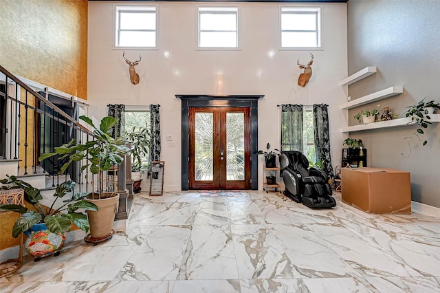 6121 County Road 225, Hungerford, TX 77448 - foyer entrance featuring a towering ceiling, french doors, stairs, marble finish flooring, and baseboards