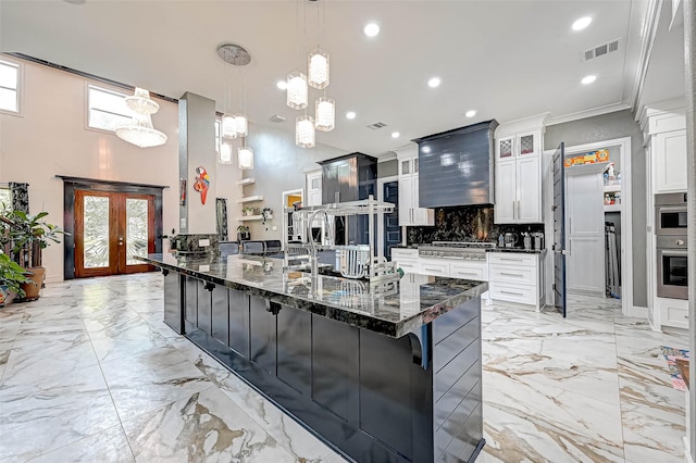 6121 County Road 225, Hungerford, TX 77448 - kitchen featuring light marble finish floors, a peninsula, decorative backsplash, glass insert cabinets, and recessed lighting