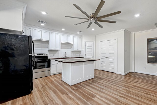 6121 County Road 225, Hungerford, TX 77448 - kitchen featuring freestanding refrigerator, stainless steel electric range, a ceiling fan, crown molding, and white cabinets