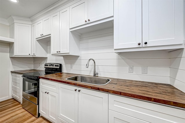 6121 County Road 225, Hungerford, TX 77448 - kitchen with wood counters, electric range, a sink, white cabinetry, and decorative backsplash