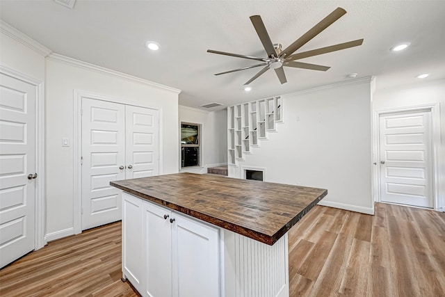 6121 County Road 225, Hungerford, TX 77448 - kitchen with wood counters, crown molding, ceiling fan, light wood finished floors, and white cabinetry