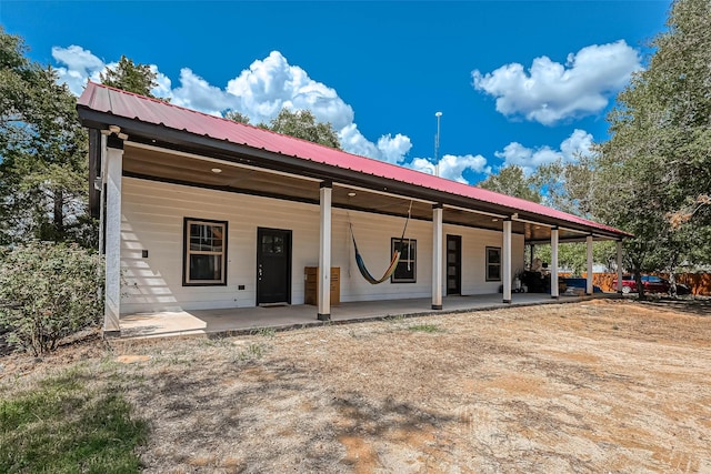 6121 County Road 225, Hungerford, TX 77448 - rear view of house featuring a porch and metal roof