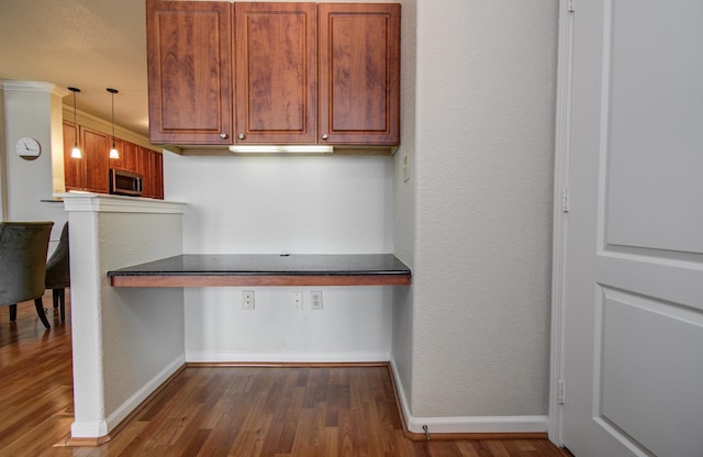 1711 Old Spanish Trl Unit 401, Houston, TX 77054 - kitchen featuring stainless steel microwave, baseboards, dark wood-type flooring, and brown cabinetry